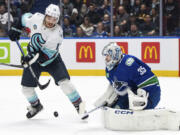 Seattle Kraken's Brandon Tanev (13) tries to tap in a shot against Vancouver Canucks goaltender Thatcher Demko (35) during the first period of an NHL hockey game Saturday, Nov. 18, 2023, in Vancouver, British Columbia.