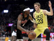 Portland Trail Blazers forward Jerami Grant, left, drives to the basket against Utah Jazz forward Lauri Markkanen during the first half of an NBA basketball game in Portland, Ore., Wednesday, Nov. 22, 2023.