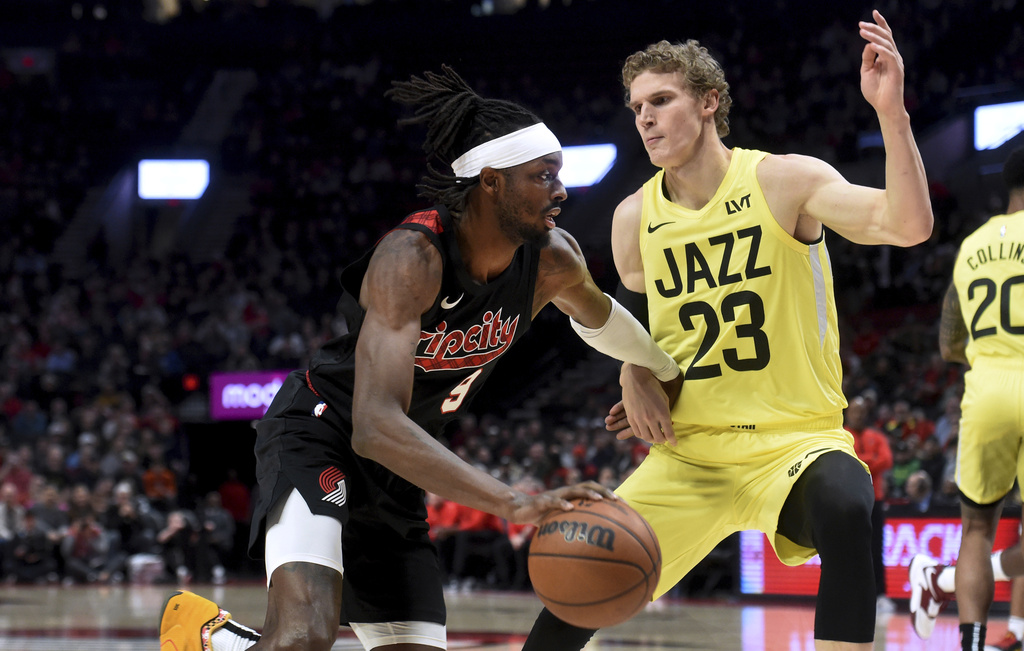 Portland Trail Blazers forward Jerami Grant, left, drives to the basket against Utah Jazz forward Lauri Markkanen during the first half of an NBA basketball game in Portland, Ore., Wednesday, Nov. 22, 2023.