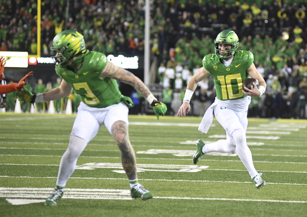 Oregon quarterback Bo Nix (10) runs for a touchdown during the first half of an NCAA college football game against Oregon State, Friday, Nov. 24, 2023, in Eugene, Ore.