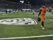Oregon State quarterback DJ Uiagalelei (5) walks by the Pac-12 logo and waves to fans after the team's game against Oregon on Friday, Nov. 24, 2023, in Eugene, Ore. This was the final Pac-12 football game for the team.