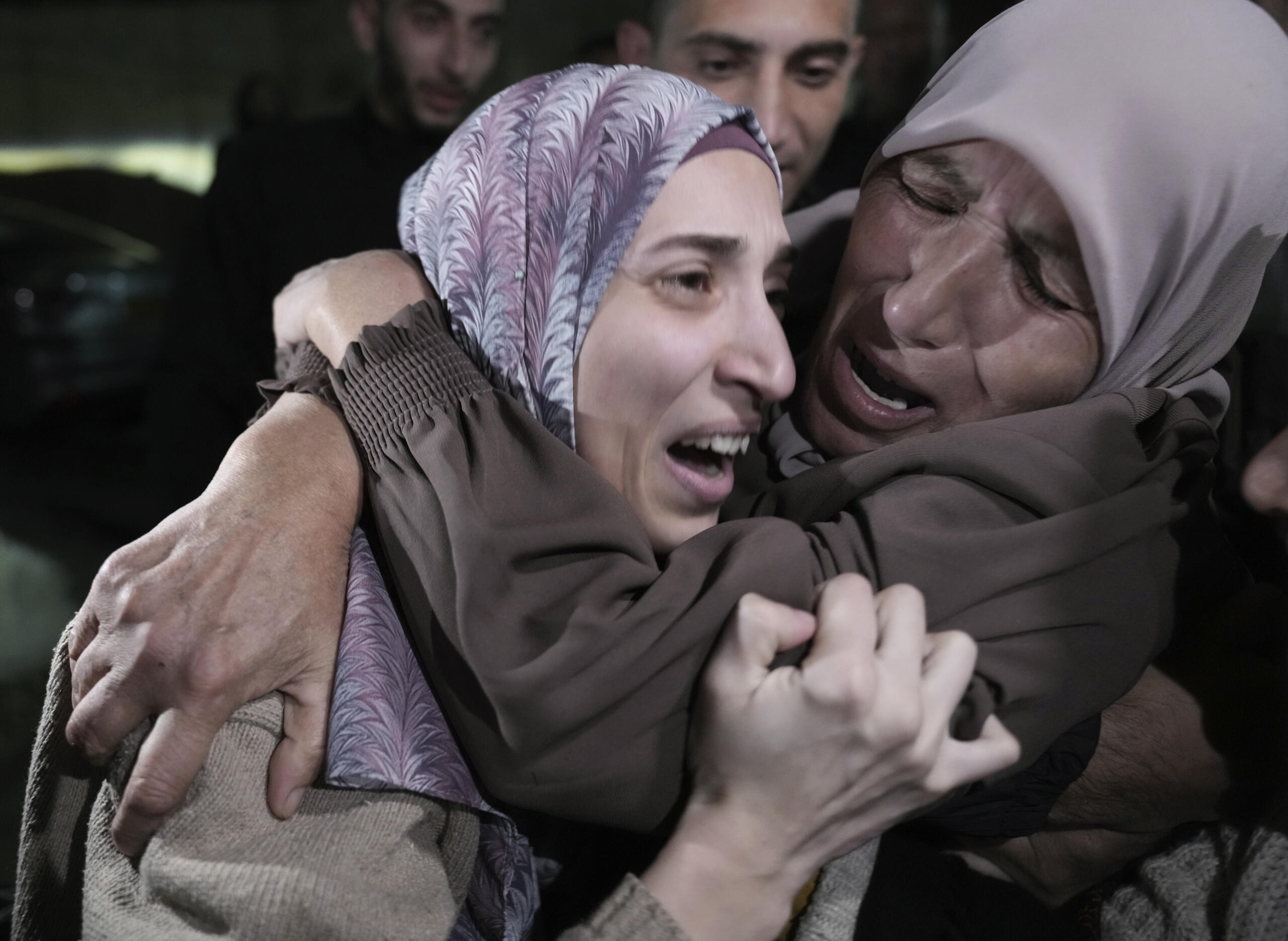 Shuruq Dwayat, left, a Palestinian prisoner released by Israel, is hugged by relatives as she arrives home in the east Jerusalem neighborhood of Sur Bahar, early Sunday Nov. 26, 2023.