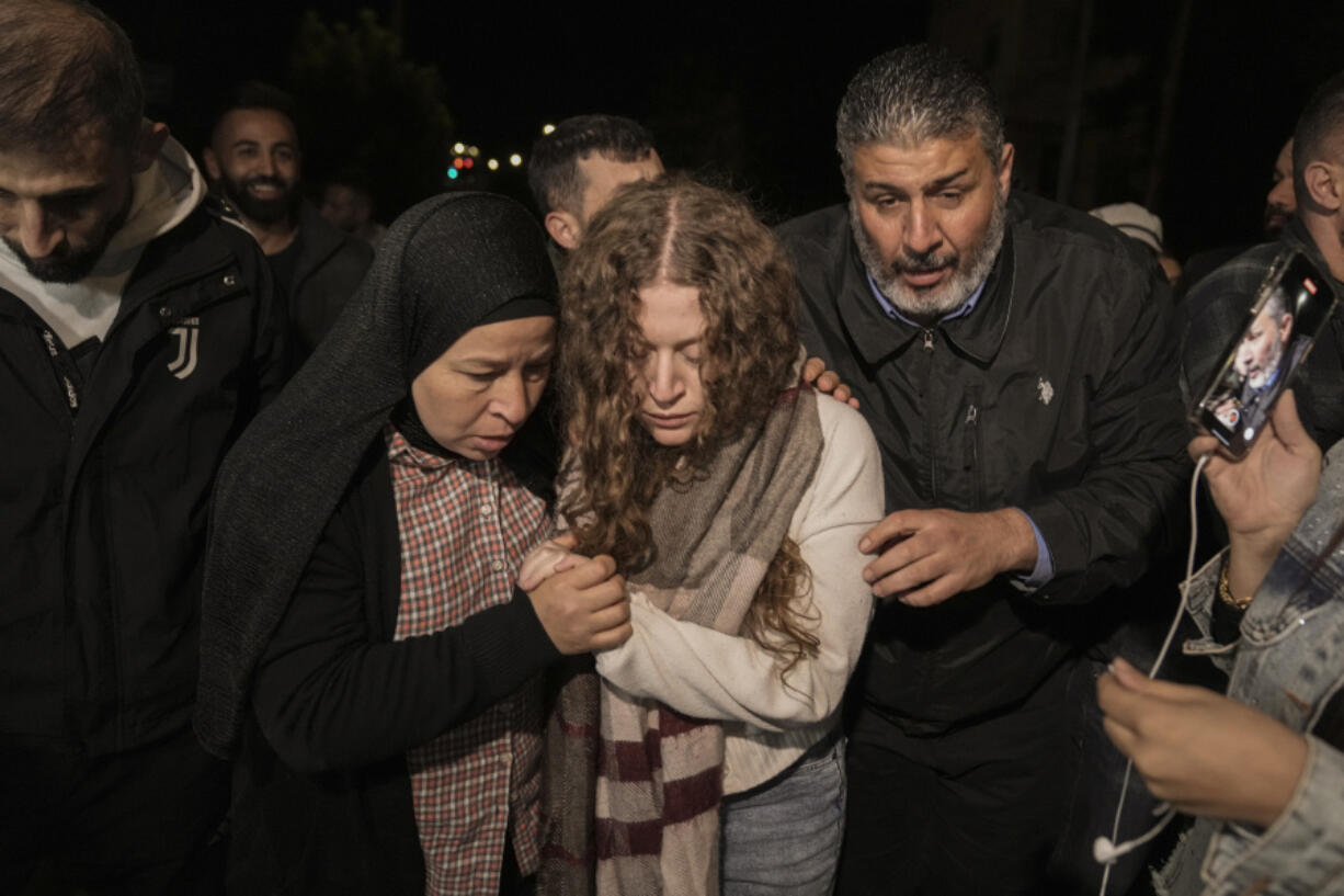Palestinian activist Ahed Tamimi, center, is supported by her mother after she was released from prison by Israel, in the West Bank town of Ramallah, early Thursday, Nov. 30, 2023. International mediators on Wednesday worked to extend the truce in Gaza, encouraging Hamas militants to keep freeing hostages in exchange for the release of Palestinian prisoners and further relief from Israel&rsquo;s air and ground offensive.