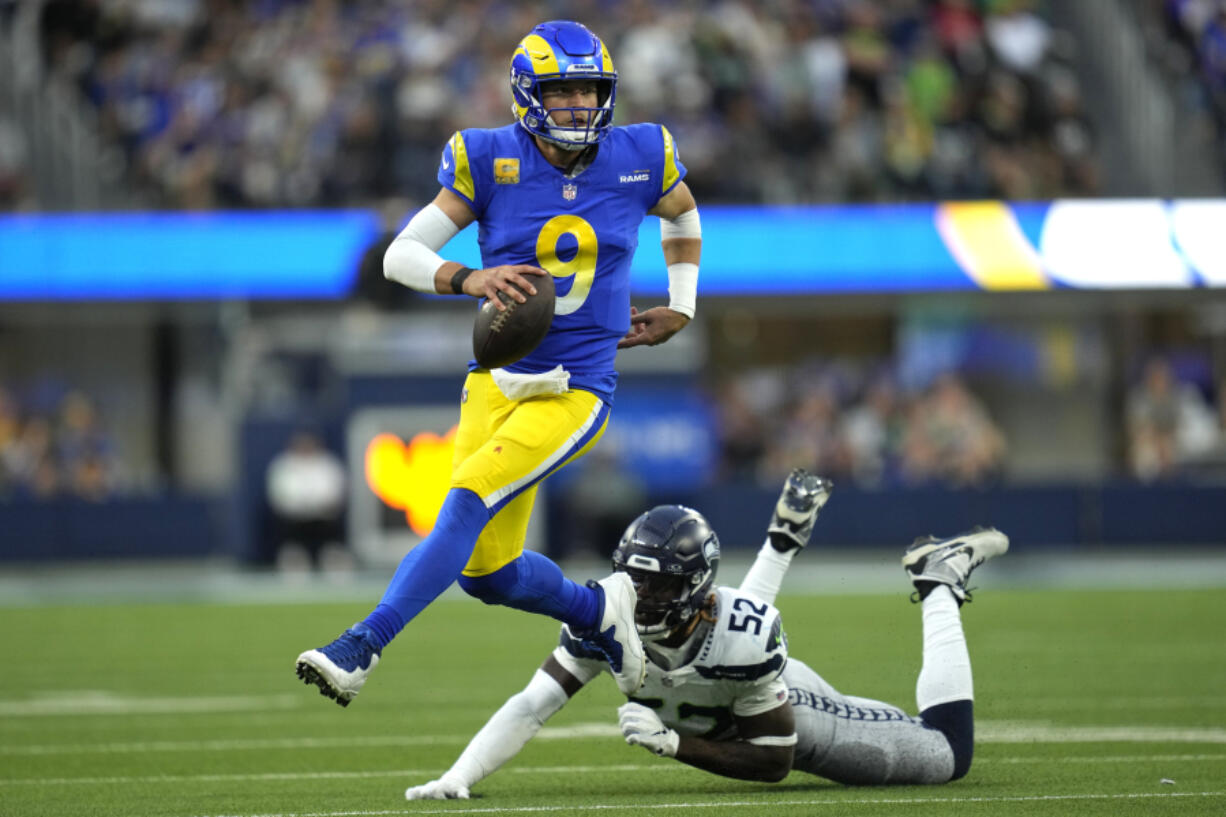 Los Angeles Rams quarterback Matthew Stafford (9) runs the ball after evading a tackle from Seattle Seahawks linebacker Darrell Taylor (52) during the second half of an NFL football game Sunday, Nov. 19, 2023, in Inglewood, Calif.