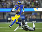 Los Angeles Rams quarterback Matthew Stafford (9) runs the ball after evading a tackle from Seattle Seahawks linebacker Darrell Taylor (52) during the second half of an NFL football game Sunday, Nov. 19, 2023, in Inglewood, Calif.