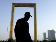 FILE - A man passes in front of the Dubai Frame in Dubai, United Arab Emirates, June 29, 2023. Dubai hosts the United Nations COP28 climate talks starting Nov. 30.