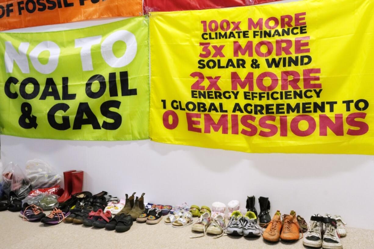 Shoes sit below signs for zero emissions at the COP28 U.N. Climate Summit, Thursday, Nov. 30, 2023, in Dubai, United Arab Emirates.