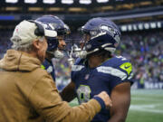 Seattle Seahawks running back Kenneth Walker III, right, celebrates with wide receiver Jaxon Smith-Njigba, center, and left, head coach Pete Carroll, in the second half of an NFL football game in Seattle against the Washington Commanders, Sunday, Nov. 12, 2023.