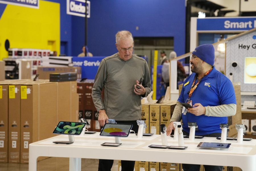 A customer and sales associate chat about mobile devices at a Best Buy store Tuesday, Nov. 21, 2023, in southeast Denver. On Thursday, the Commerce Department issues its October report on consumer spending.