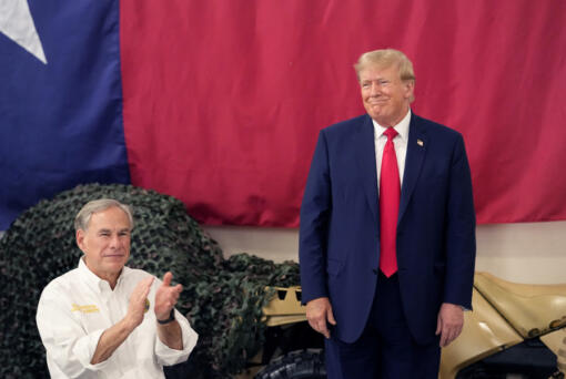Republican presidential candidate and former President Donald Trump, right, is introduced by Texas Gov. Greg Abbott at the South Texas International Airport Sunday, Nov. 19, 2023, in Edinburg, Texas. Abbott and Trump help serve a Thanksgiving meal to Texas state troopers and guardsmen.