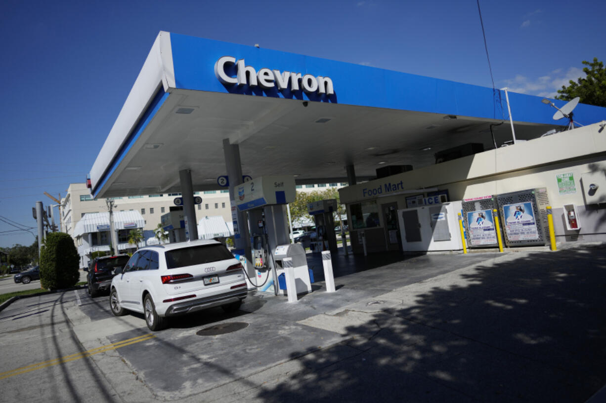 File - Drivers refuel at a Chevron gas station, Monday, Oct. 23, 2023, in South Miami, Fla. A big explanation for the recent decline in gas prices is seasonality &mdash; with prices at the pump almost always easing at this time of year.