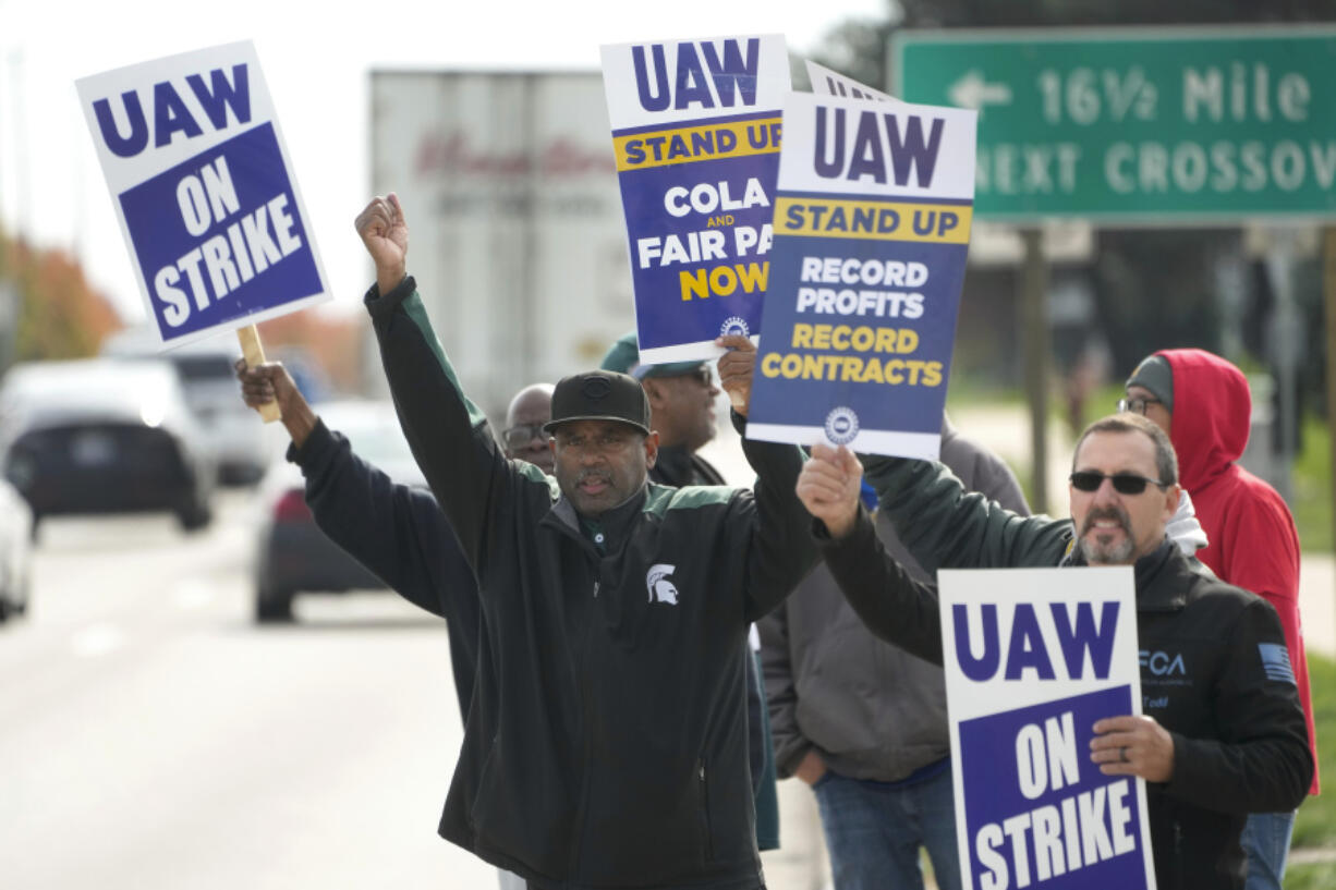 FILE - United Auto Workers members walk the picket line during a strike at the Stellantis Sterling Heights Assembly Plant, in Sterling Heights, Mich., Monday, Oct. 23, 2023. A six-week United Auto Workers strike at Ford cut sales by about 100,000 vehicles and cost the company $1.7 billion in lost profits this year, Ford said Thursday, Nov. 30, 2023.