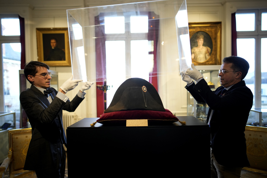 Raphael Pitchal, left, and Jean Christophe Chataignier of Osenat&rsquo;s auction house remove the protection of one of the signature broad, black hats that Napol&eacute;on wore when he ruled 19th century France and waged war in Europe at Osenat&rsquo;s auction house Nov. 17 in Fontainebleau, south of Paris.