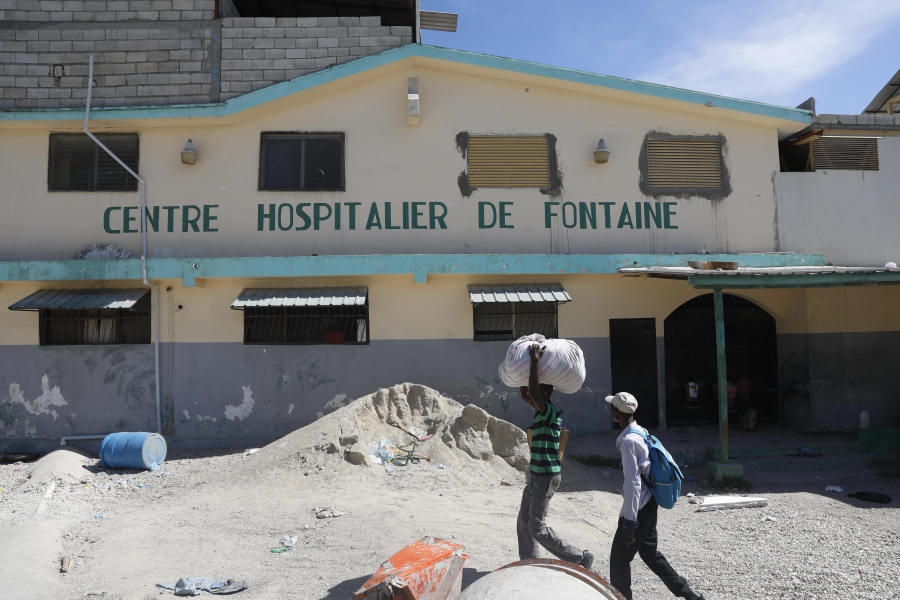 People walk past the temporarily closed Fontaine Hospital Center the day after it was attacked in the Cit&eacute; Soleil area of Port-au-Prince, Haiti, Thursday, Nov. 16, 2023. A heavily armed gang surrounded the hospital on Wednesday, trapping women, children and newborns inside until police rescued them, according to the director of the medical center.