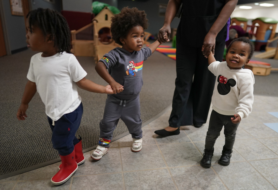 A toddler teacher walks toddlers to a classroom at the Life Learning Center - Head Start, in Cincinnati, Tuesday, Nov. 21, 2023. A new plan from the Biden administration could significantly increase salaries for hundreds of low-paid early childhood teachers caring for the country&rsquo;s poorest children but might also force some centers to cut enrollment.