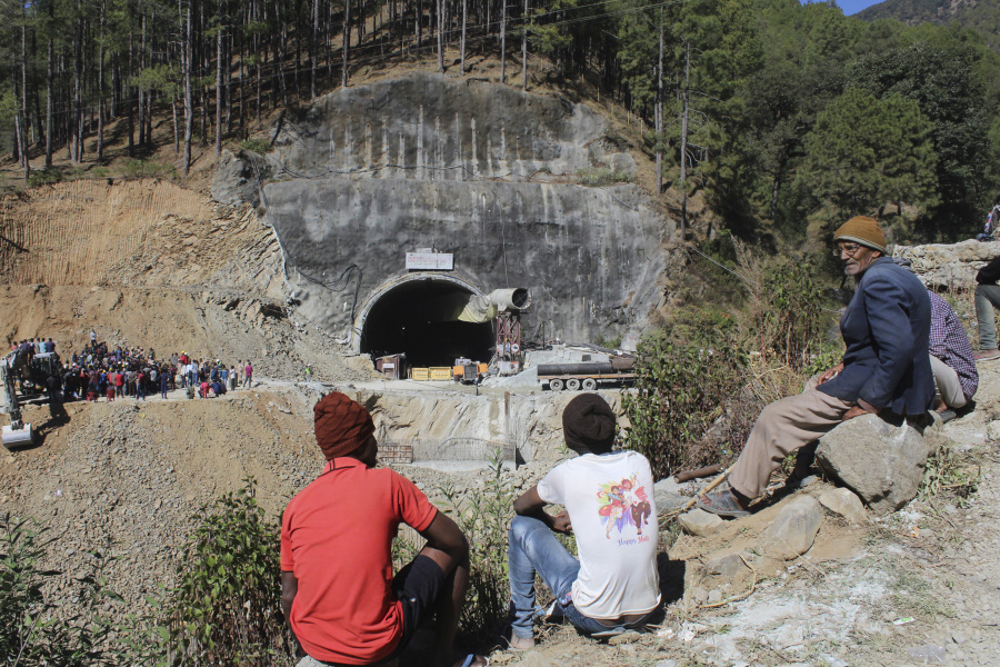 People watch rescue and relief operations at the site of an under-construction road tunnel that collapsed in mountainous Uttarakhand state, India, Wednesday, Nov. 15, 2023. Rescuers have been trying to drill wide pipes through excavated rubble to create a passage to free 40 construction workers trapped since Sunday. A landslide Sunday caused a portion of the 4.5-kilometer (2.7-mile) tunnel to collapse about 200 meters (500 feet) from the entrance. It is a hilly tract of land, prone to landslide and subsidence.