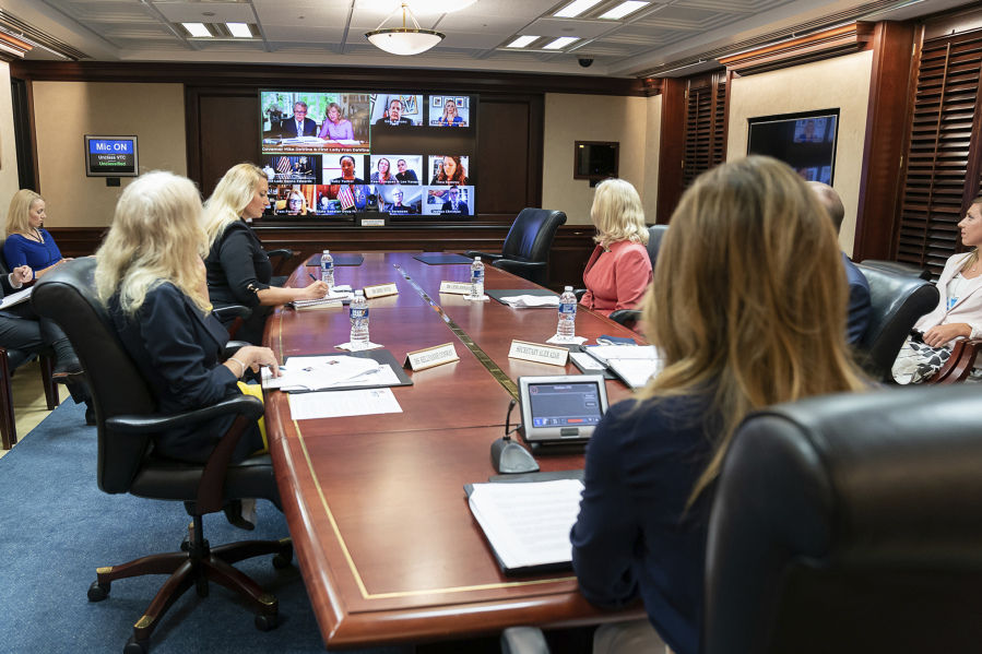 In this June 30, 2020 photo provided by the White House, first lady Melania Trump, joined by Health and Human Services Secretary Alex Azar, Senior Counselor to the President Kellyanne Conway and White House senior advisers, participate in a roundtable discussion on foster care and strengthening America&rsquo;s child welfare system, in the Situation Room in the White House in Washington. On screen, middle row at right is Adoption-Share founder and CEO Thea Ramirez. Trump spotlighted Ramirez&rsquo;s work at the foster care event.