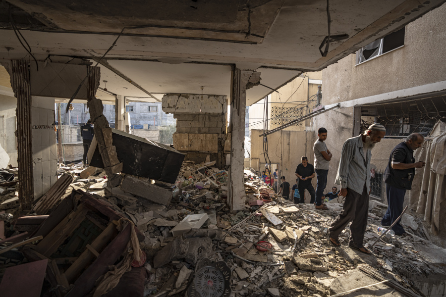 Palestinians look at the destruction after Israeli strikes on the Gaza Strip in Khan Younis, Friday, Now. 3, 2023.
