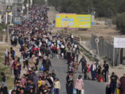 Palestinians flee to the southern Gaza Strip along Salah al-Din Street in Bureij, Gaza Strip, Thursday, Nov. 9, 2023.