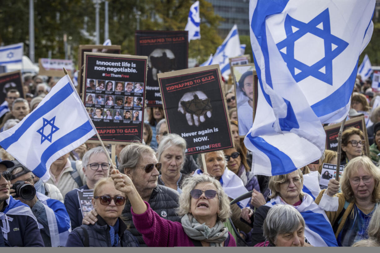 FILE - Protesters hold banners with hostages&#039; pictures and Israel flags during a gathering next to the European headquarters of the United Nations in Geneva, Switzerland, on Oct. 22, 2023. Antisemitism is spiking across Europe after Hamas&#039; Oct. 7 massacre and Israel&#039;s bombardment of Gaza, worrying Jews from London to Geneva and Berlin.