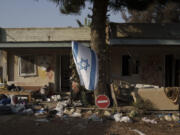 FILE - An Israeli flag hangs between destroyed houses in the kibbutz Kfar Azza, Israel, near the Gaza Strip, Monday, Nov. 13, 2023. It has become an Israeli mantra throughout the latest war in Gaza: Hamas is ISIS. Since the bloody Hamas attack on Oct. 7 that triggered the war, Israeli leaders and commanders have likened the Palestinian militant group to the Islamic State group. They point to Hamas&rsquo; brutal slaughter of hundreds of civilians and compare their Gaza war to the U.S.-led campaign to defeat IS in Iraq and Syria.