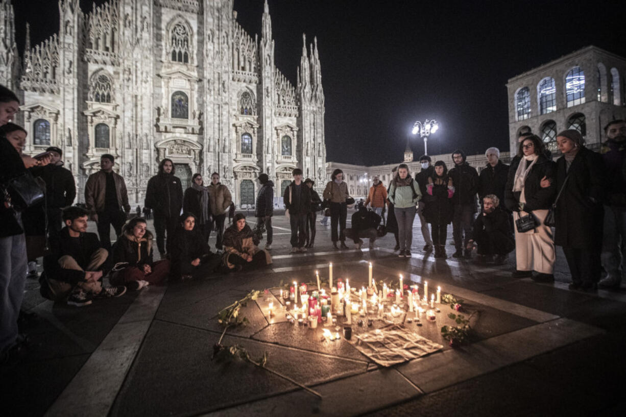 FILE - People attend a candlelight vigil for 22-year-old Giulia Cecchettin, allegedly killed at the hands of her possessive ex-boyfriend, in front of the Milan Duomo Cathedral,  Italy, Sunday, Nov. 19, 2023.  Outrage over violence against women is mounting in Italy, with students leading the way. Young people across the country have taken to pounding on classroom desks in unison to demand an end to the slayings of women by men and to root out corrosive, patriarchal attitudes that have long been a part of Italian society. Opposition lawmakers did the same in parliament.