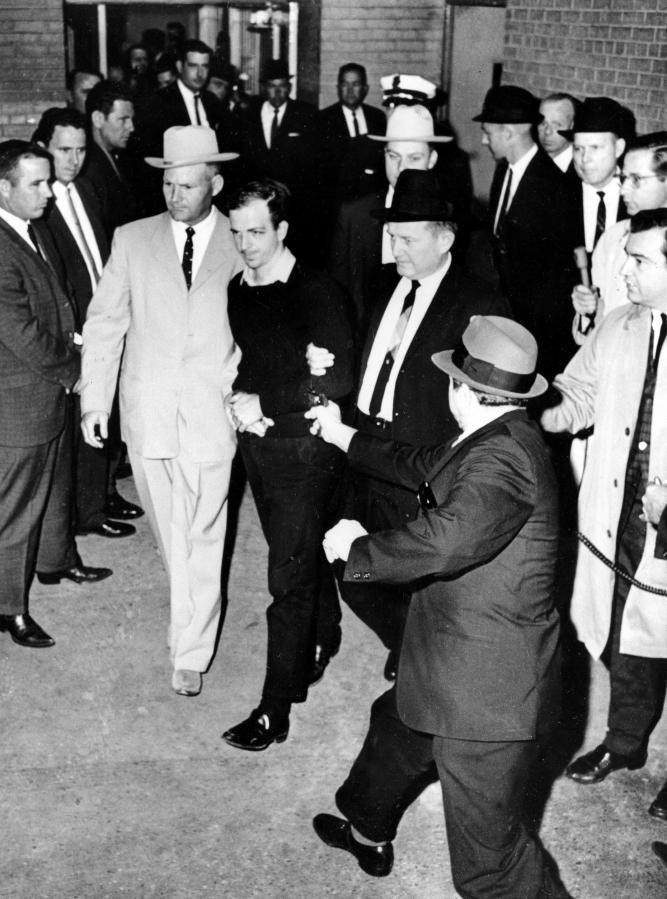FILE- President John F. Kennedy assassin Lee Harvey Oswald, center in handcuffs, is shot by Jack Ruby, foreground, in the underground garage of the Dallas police headquarters on Nov. 24, 1963. Peggy Simpson, a former Associated Press reporter, is among the last surviving witnesses to the events surrounding the assassination of Kennedy are among those sharing their stories as the nation marks the 60th anniversary.