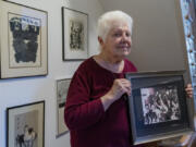 Peggy Simpson holds a photograph of law enforcement carrying Lee Harvey Oswald&rsquo;s gun through a hallway packed with reporters, Friday, Nov. 17, 2023, at her home in Washington. Simpson, a former Associated Press reporter, is among the last surviving witnesses to the events surrounding the assassination of Kennedy are among those sharing their stories as the nation marks the 60th anniversary.