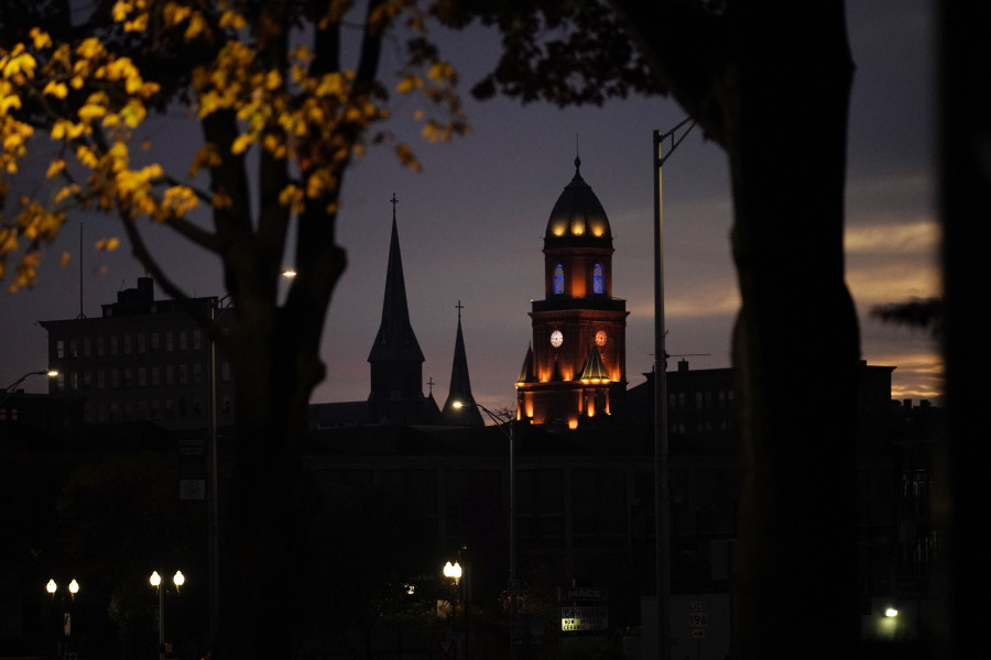 City Hall tower and church steeples are seen at dawn in Lewiston, Maine is seen at dawn, Thursday, Oct. 26, 2023. Residents have been ordered to shelter in place as police continue to search for the suspect of Wednesday's mass shooting at a local bar. (AP Photo/Robert F.