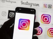 File - The Instagram logo is seen on a cell phone in Boston, USA, Oct. 14, 2022. The owner of Facebook and Instagram says it'll put labels on political ads created using artificial intelligence. The new policy announced Wednesday by Meta goes into effect Jan. 1 and will apply worldwide.
