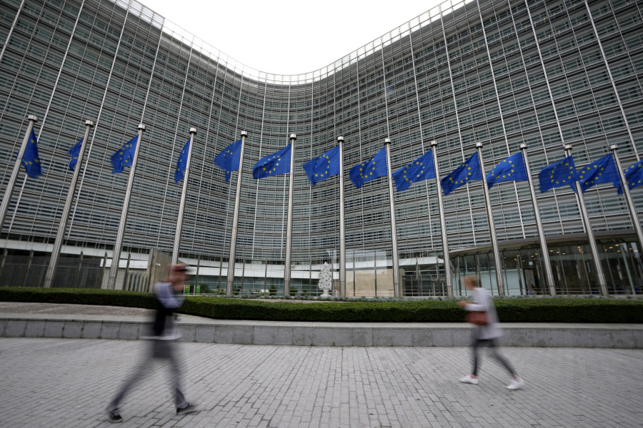 FILE - European Union flags flap in the wind as pedestrians walk by EU headquarters in Brussels, Sept. 20, 2023. European officials widened a ban on Meta's "behavioral advertising" practices to most of Europe on Wednesday, Nov. 1, setting up a broader conflict between the continent's privacy-conscious institutions and an American technology giant.
