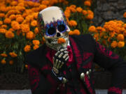 A Mexican mascot dressed as a catrin, a masculine version of the Day of the Dead Catrina, poses for photographers at the Hermanos Rodriguez race track in Mexico City, Thursday, Oct. 26, 2023. The track is hosting the Mexico City Grand Prix which begins Friday.