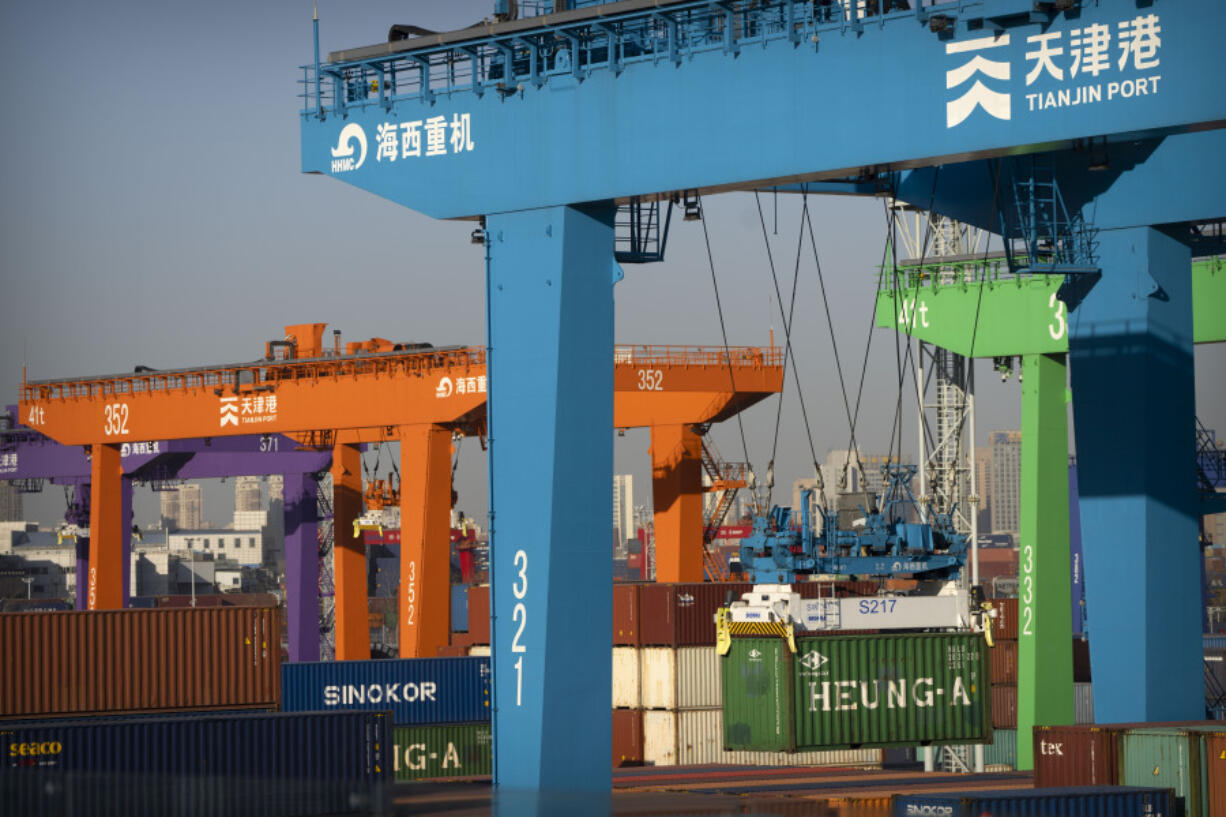 File - A crane lifts a shipping container at an automated container port in Tianjin, China, Jan. 16, 2023. The global economy, which has proved surprisingly resilient this year, is expected to falter next year under the strain of wars, still-elevated inflation and continued high interest rates.