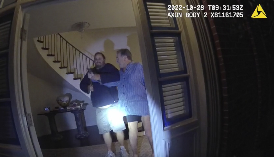 FILE - In this image taken from San Francisco Police Department body-camera video, the husband of former U.S. House Speaker Nancy Pelosi, Paul Pelosi, right, fights for control of a hammer with his assailant David DePape during a brutal attack in the couple&rsquo;s San Francisco home on Oct. 28, 2022. Opening statements are scheduled for Thursday, Nov. 8, 2023, in the federal trial of the man accused of breaking into former House Speaker Nancy Pelosi&rsquo;s San Francisco home seeking to kidnap her and bludgeoning her husband with a hammer.