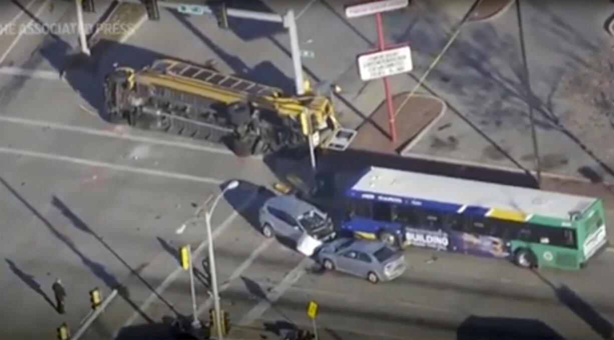 This image made from video provided by WISN-TV shows where a vehicle wanted in connection with a homicide in Chicago crashed into a school bus during a police chase in Milwaukee on Wednesday, Nov. 29, 2023, sending multiple people to area hospitals.