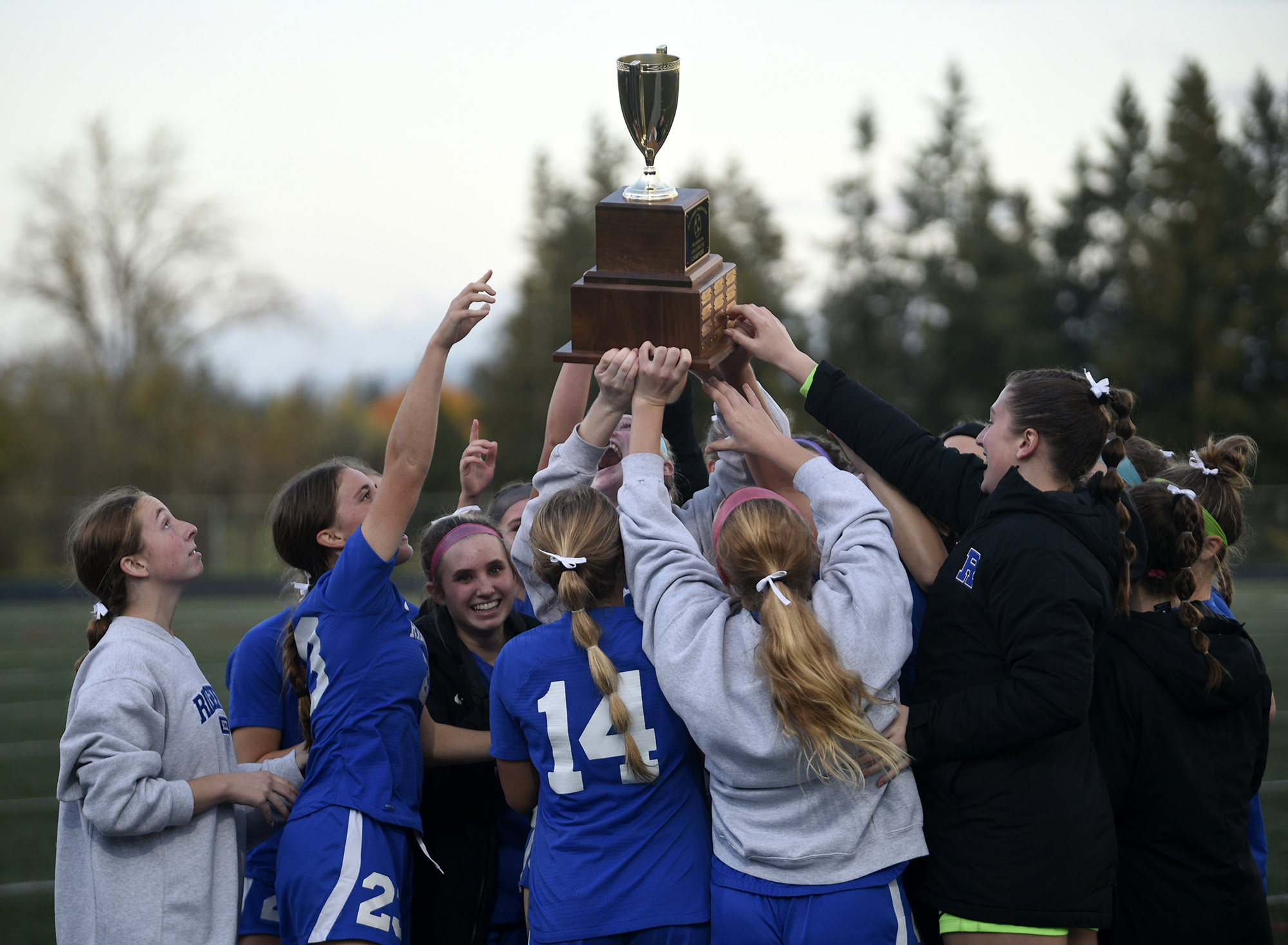 The Ridgefield girls soccer team celebrate with the championship trophy after the Spudders’ 3-0 win over R.A. Long in the Class 2A girls soccer district championship game at Ridgefield High School on Saturday, Nov. 4, 2023.
