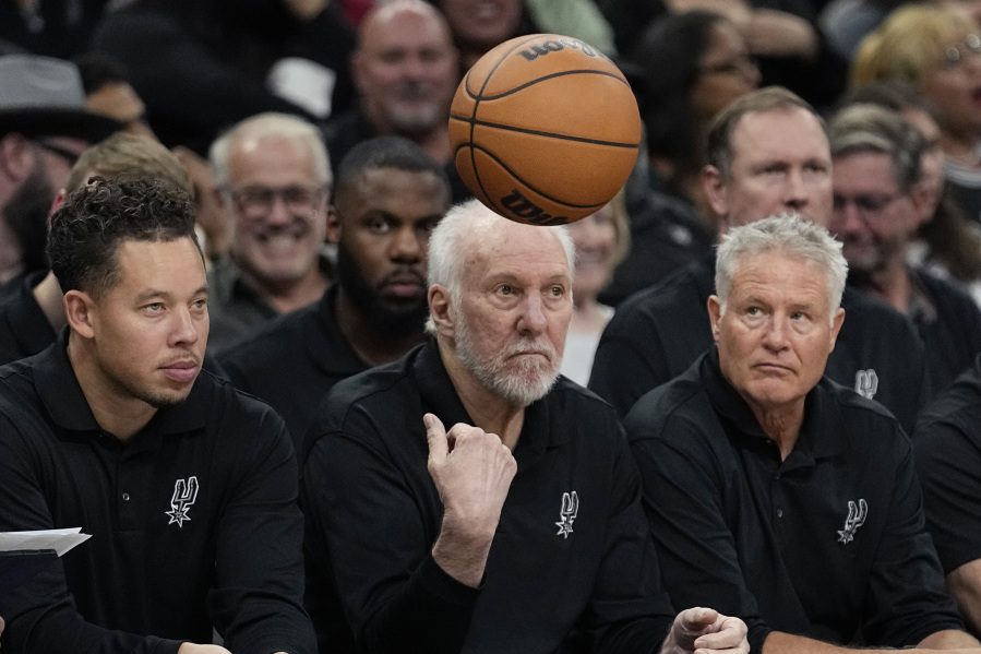 San Antonio Spurs head coach Gregg Popovich, center, flips the ball back to an official during the second half of a preseason NBA basketball game against the Houston Rockets in San Antonio, Monday, Oct. 16, 2023.