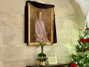 A black mourning drape over the oil canvas portrait of former first lady Rosalynn Carter, painted by American artist George Augusta in 1984, hangs in the White House, Monday, Nov. 27, 2023 in Washington.