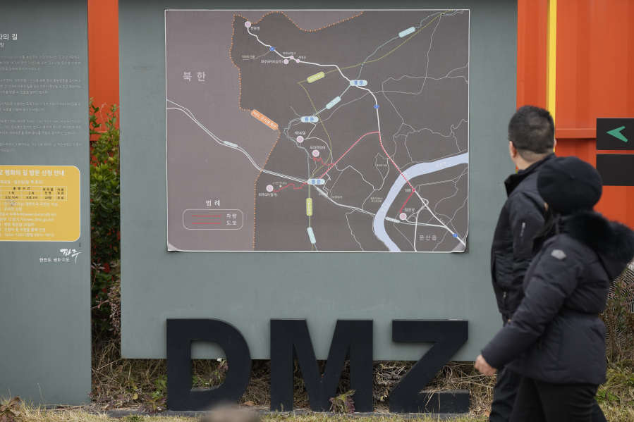 Visitors walk past near a map of the Demilitarized Zone (DMZ) at the Imjingak Pavilion in Paju, South Korea, Wednesday, Nov. 22, 2023. South Korea will partially suspend an inter-Korean agreement Wednesday to restart frontline aerial surveillance of North Korea, after the North said it launched a military spy satellite in violation of United Nations bans, Seoul officials said.