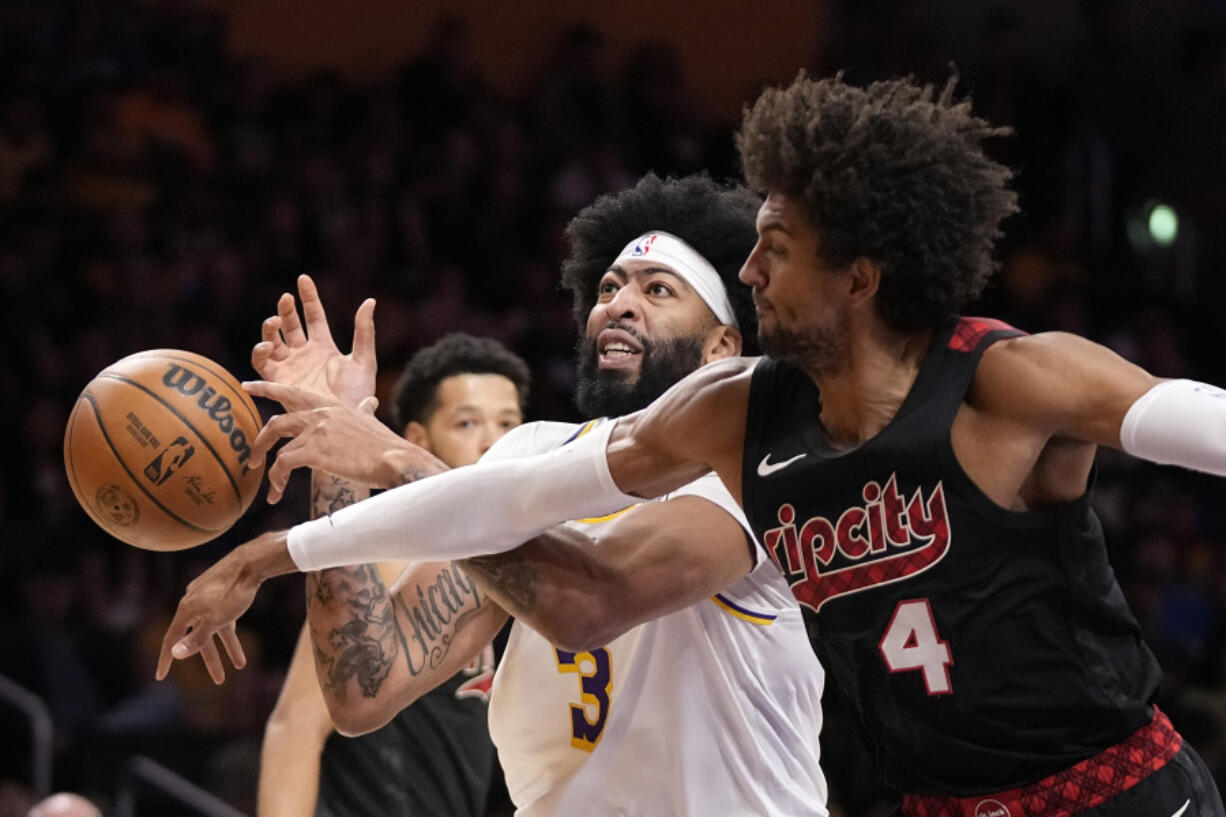 Portland Trail Blazers guard Matisse Thybulle, right, knocks the ball from the hands of Los Angeles Lakers forward Anthony Davis during the first half of an NBA basketball game Sunday, Nov. 12, 2023, in Los Angeles. (AP Photo/Mark J.