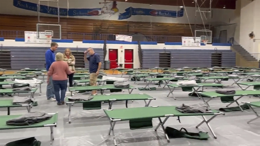 This image taken from video and provided by WTVQ shows people helping arrange cots at Rockcastle Middle School, being used as an evacuation center, in Mt Vernon, Ky., Wednesday, Nov. 22, 2023. People were evacuated from a nearby town after a CSX train derailed Wednesday near Livingston, a remote town with about 200 people in Rockcastle County. CSX says two of the 16 cars that derailed carried molten sulfur, which caught fire after the cars were breached.
