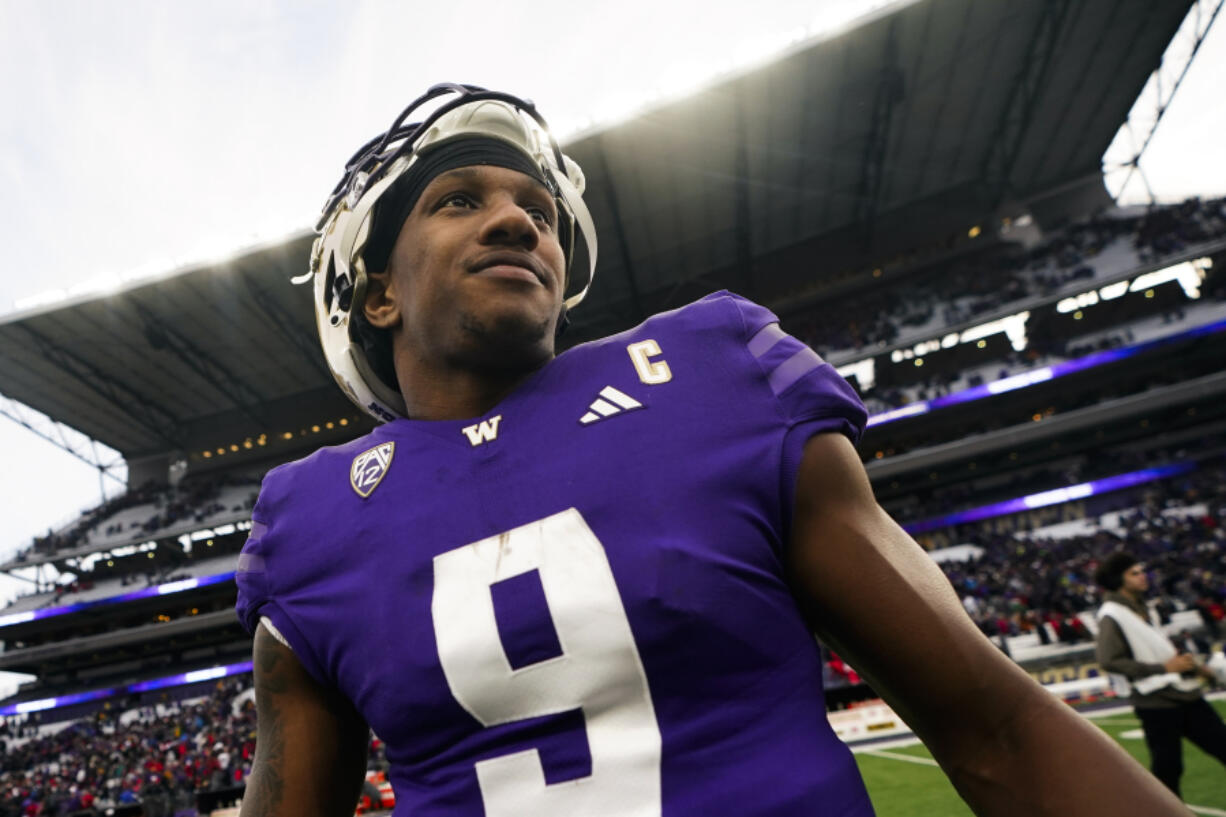 Washington quarterback Michael Penix Jr. smiles on the field following a 35-28 victory over Utah in an NCAA college football game Saturday, Nov. 11, 2023, in Seattle.