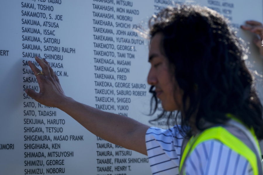 Jonnie Narita places a hand on the honor roll at the entrance of the Minidoka National Historic Site.