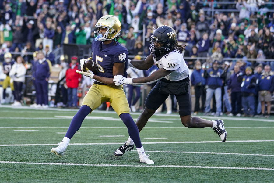 Notre Dame wide receiver Tobias Merriweather (5) makes a catch for a touchdown in front of Wake Forest defensive back Caelen Carson (1) during the first half of an NCAA college football game in South Bend, Ind., Saturday, Nov. 18, 2023.