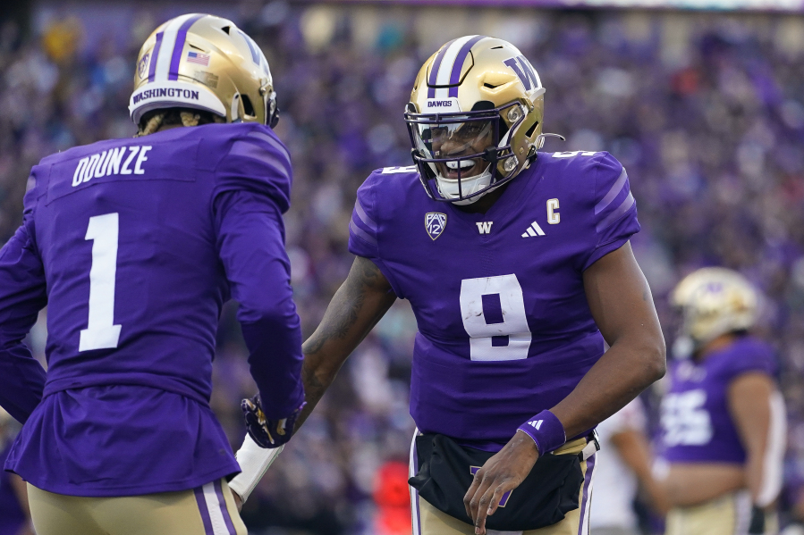 Washington quarterback Michael Penix Jr. (9) celebrates throwing a touchdown to wide receiver Rome Odunze (1) against Washington State during the first half of an NCAA college football game, Saturday, Nov. 25, 2023, in Seattle.