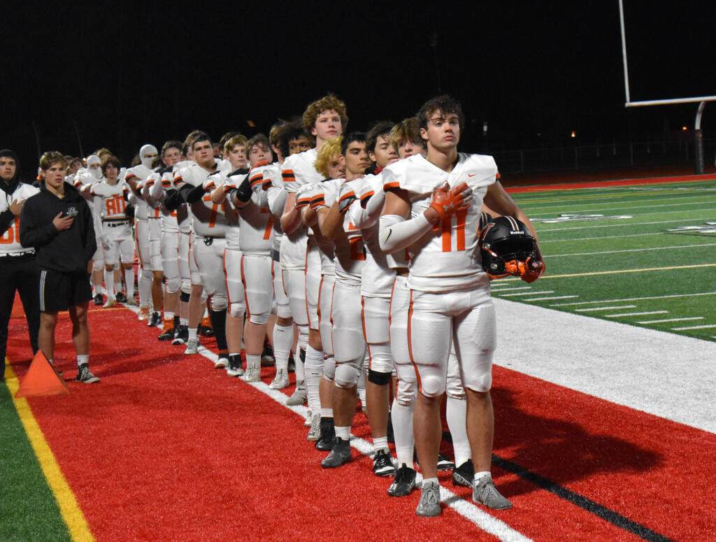 The members of the Washougal football team stand for the national anthem prior to their game against Orting in the Class 2A state first-round game at Orting High School on Friday, Nov. 10, 2023.
