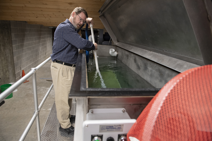 Supervisor John Dunn describes how forensic scientists use a water tank to retrieve bullets without damaging them at the Washington State Patrol Crime Lab in Vancouver.
