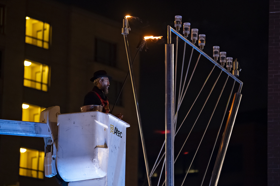 Rabbi Shmulik Greenberg leads the crowd as they celebrate the beginning of Hanukkah with the lighting of the menorah Thursday evening at Esther Short Park in downtown Vancouver.