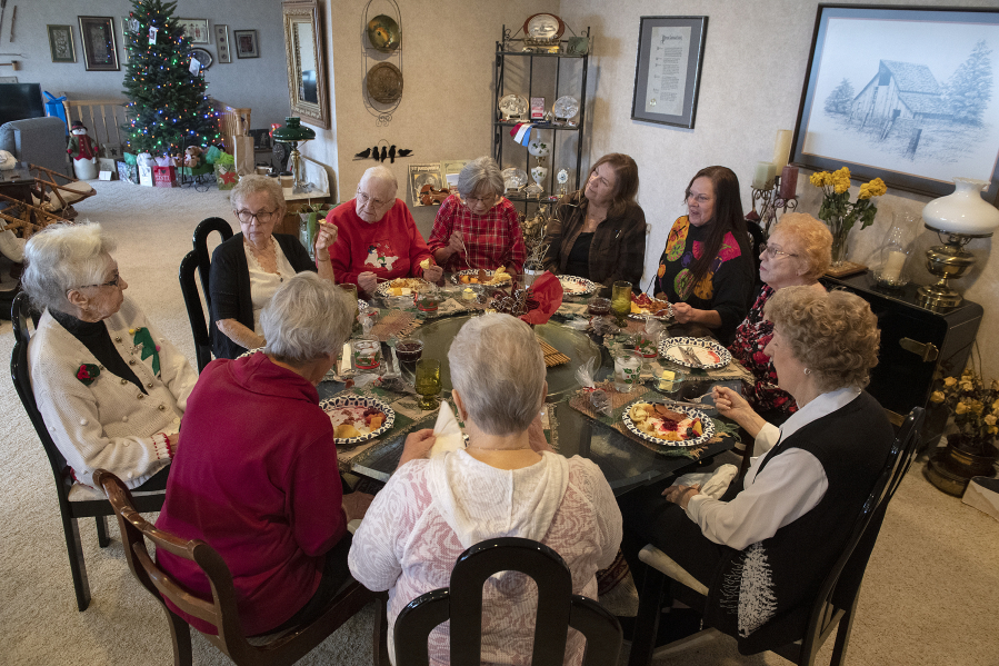 Rose Funk of Vancouver, left, hosts her former Girl Scouts troop, the Evergreen Pollyannas, for a holiday potluck on Dec. 6. The group has been meeting once a month for 75 years.
