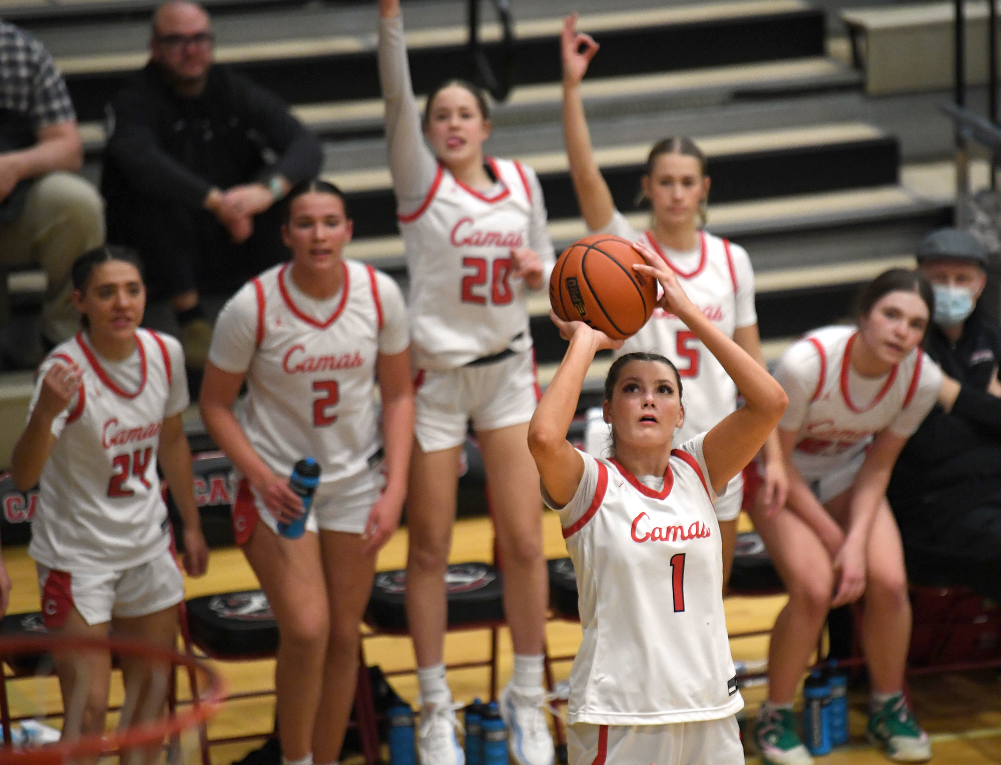 The Camas bench gets ready to celebrate as senior Reagan Jamison shoots a three point shot Friday, Dec. 15, 2023, during the Papermakers’ 58-46 win against Eastlake at Camas High School.
